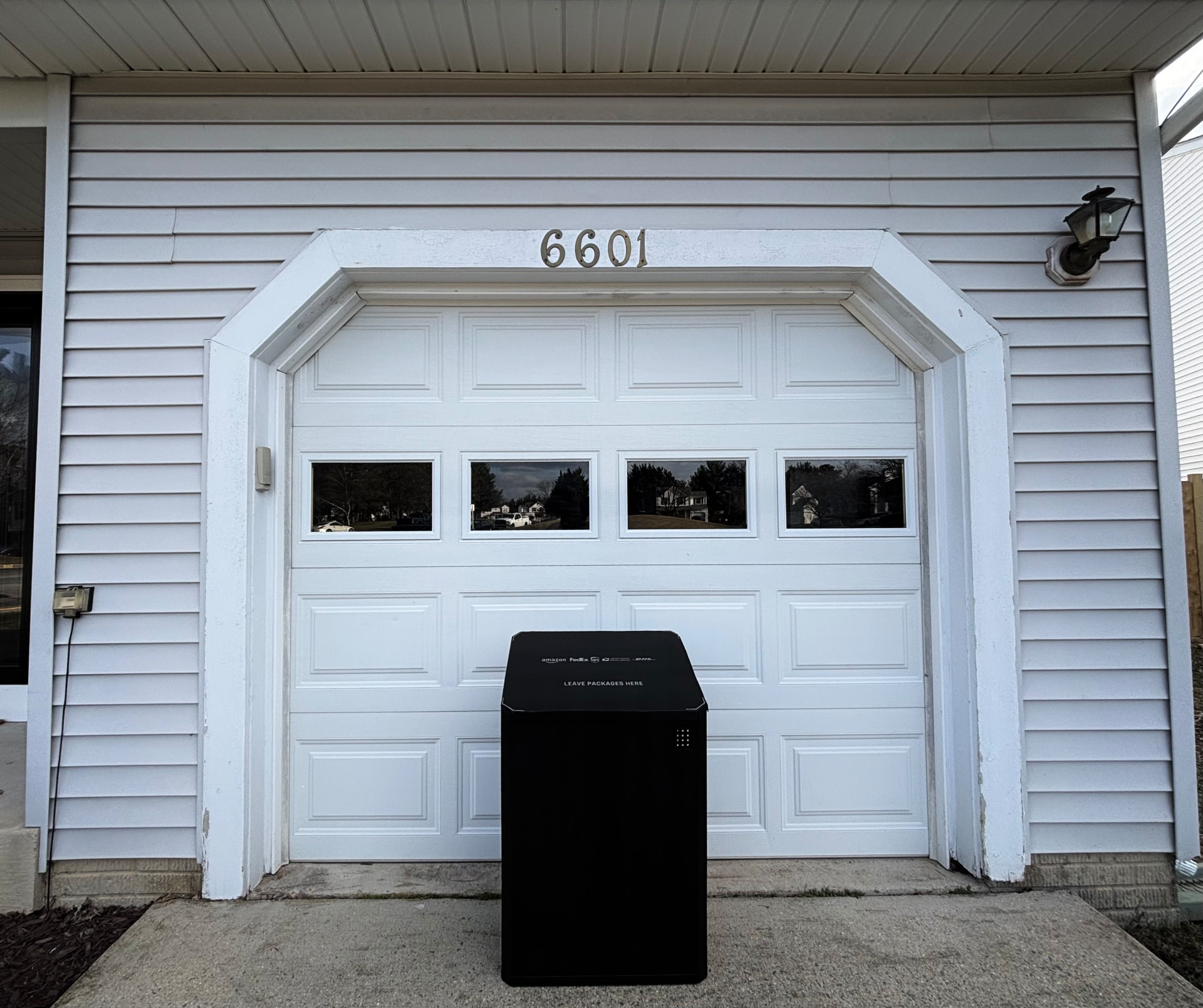SG-1 sitting on a driveway in front of a suburban garage door